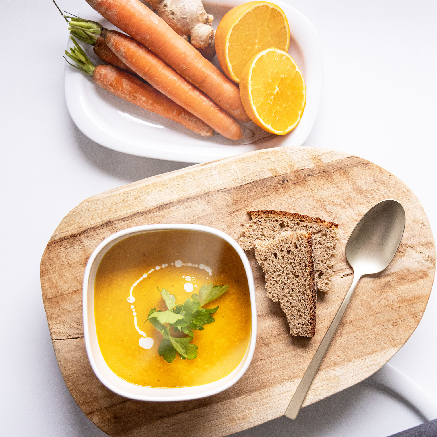 Rosenthal Suomi bowl filled with pumpkin cream on a wooden tray with carrots in the background